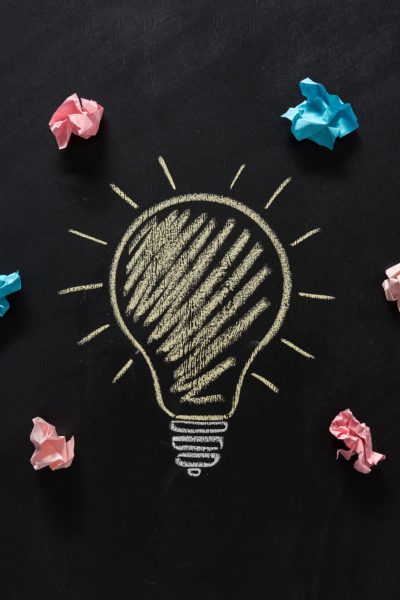 top view of paper rubbish lying around of electric bulb drawn on blackboard
